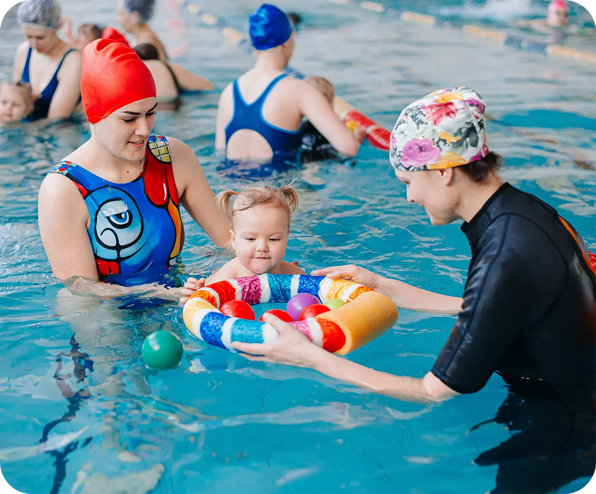 Child practicing one-on-one swim lesson with instructor at FINS Swim School.
