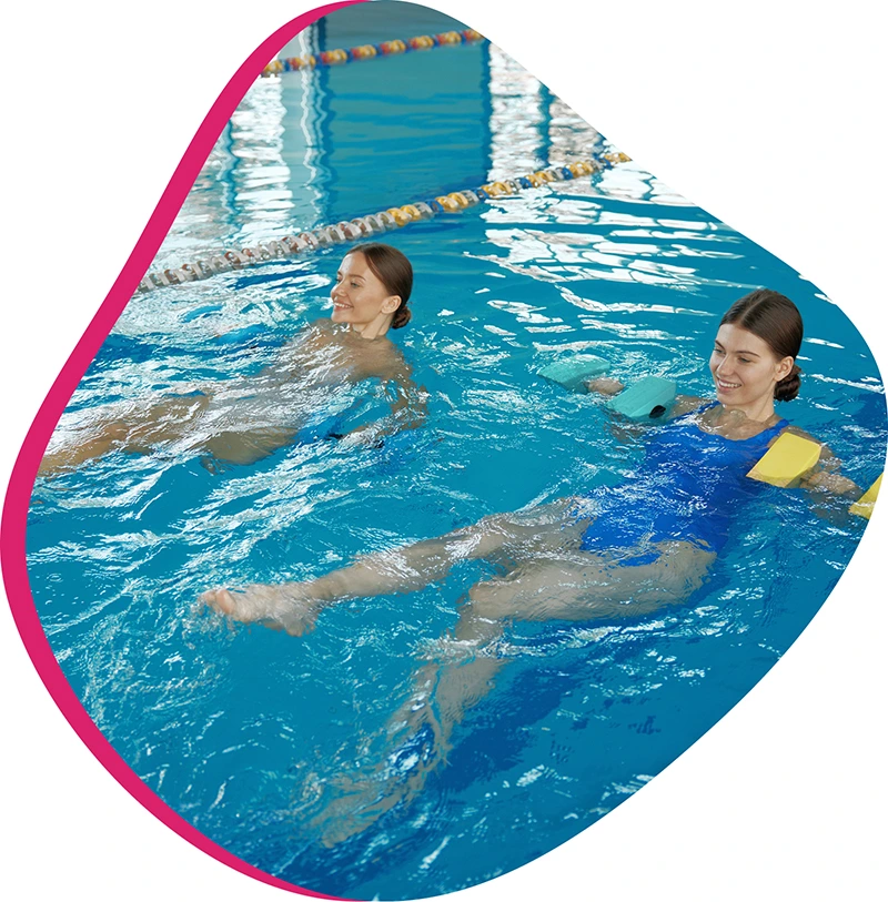 Adults participating in an Aqua Fitness class at FINS Swim School's indoor pool.