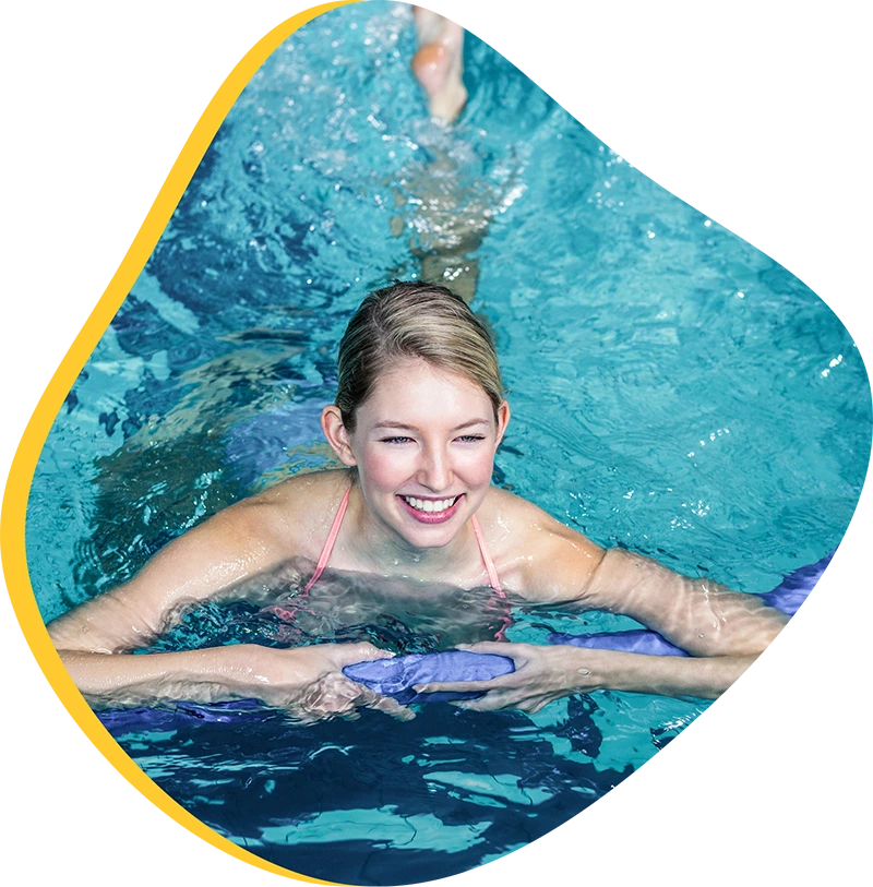 Adults participating in an Aqua Fitness class at FINS Swim School's indoor pool.