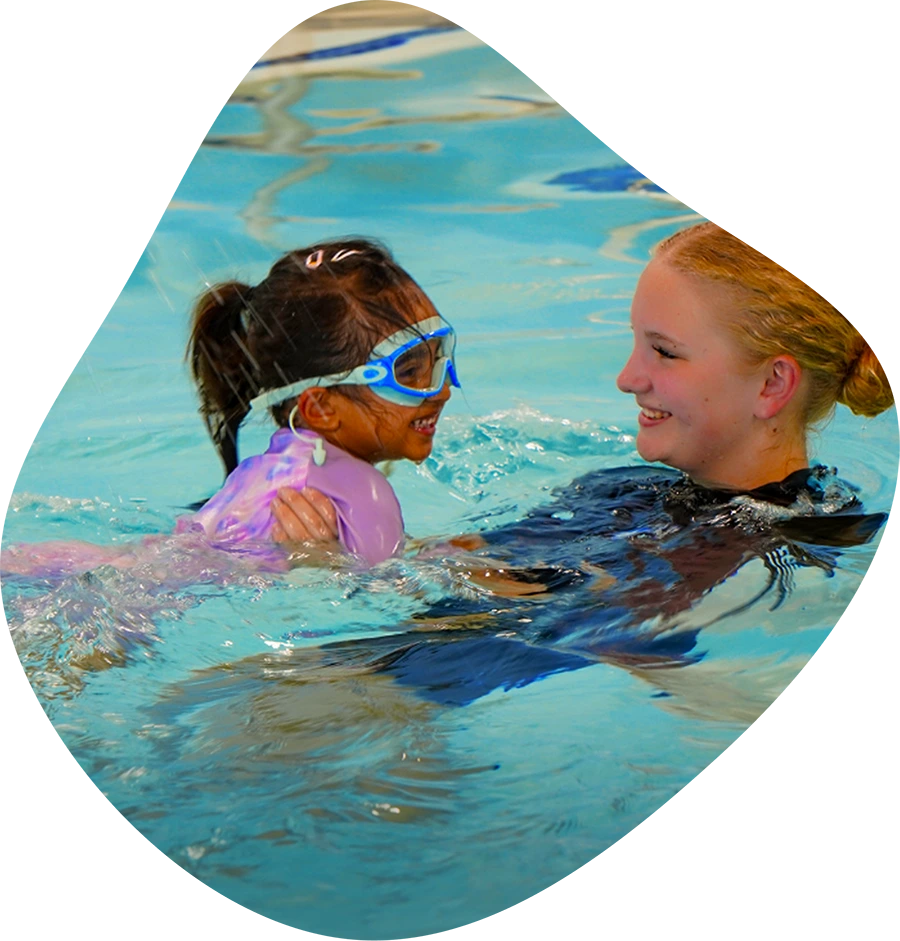 A student and instructor practicing professional swim techniques in the Spring, TX, indoor facility.