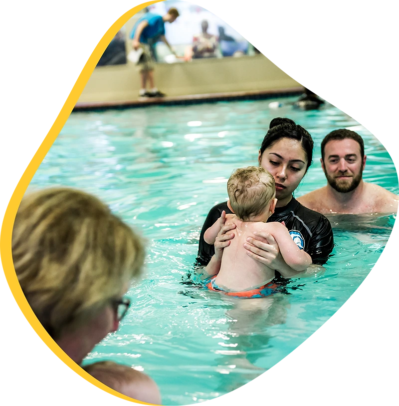 A parent and infant participating in a gentle water acclimation class at FINS Cypress.
