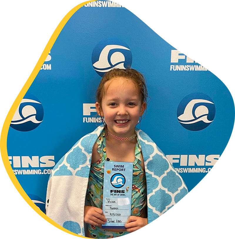 A young swimmer practicing freestyle stroke during a private one-on-one swim lesson at FINS Atascocita.