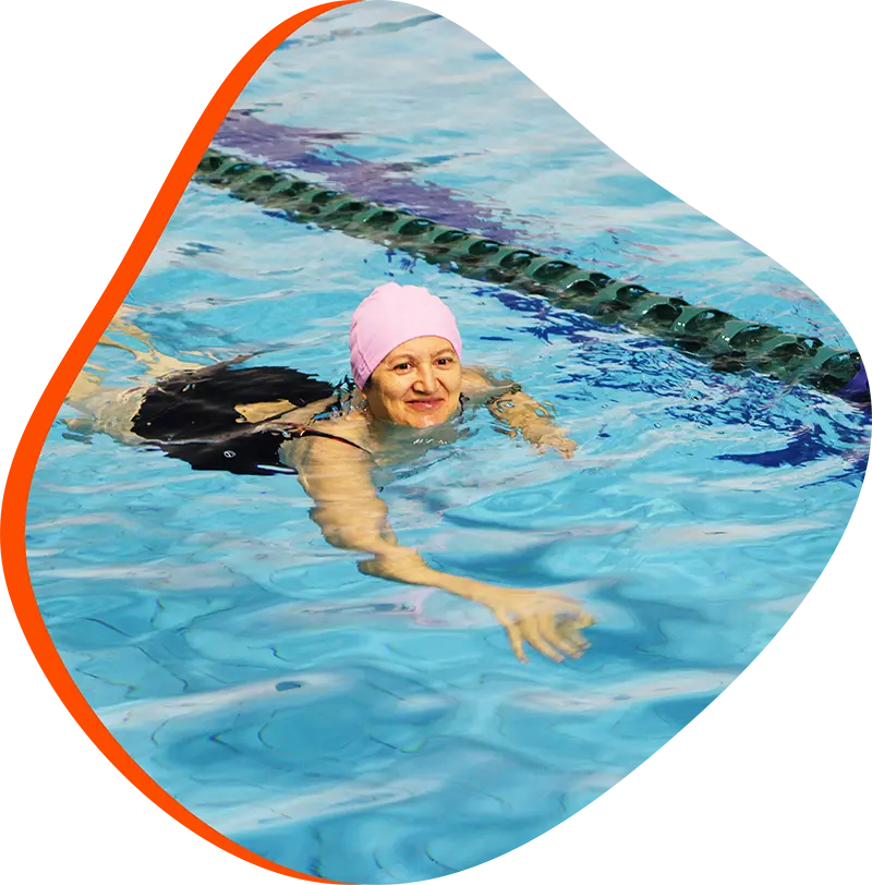 Adult swimmer receiving one-on-one instruction at FINS Swim School Fleet indoor pool
