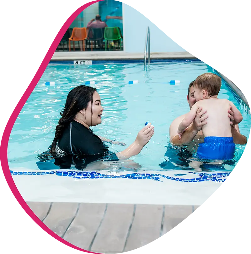 A parent and infant participating in a gentle water acclimation class at FINS Cypress.