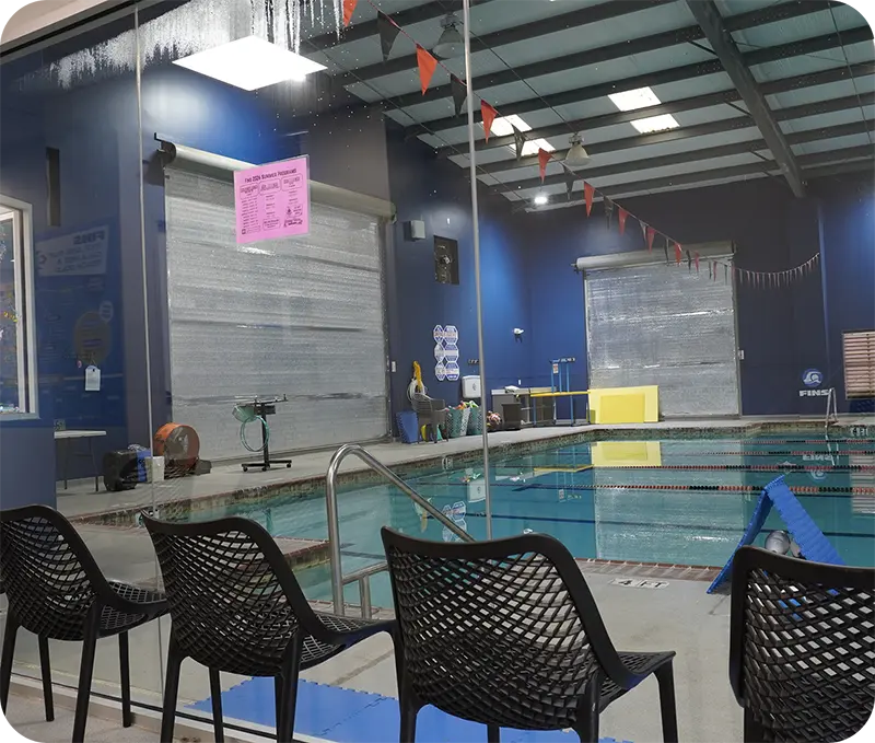 A student and instructor practicing professional swim techniques in the Spring, TX, indoor facility.