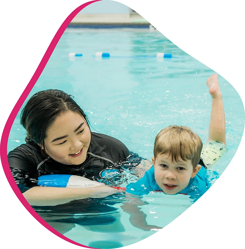 A school-aged child practicing correct freestyle stroke technique during a private 1-on-1 swim lesson.